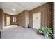 Spacious hallway with tiled floors, brick walls, and a view of unit's entrance with a green plant at 84 Lake Concord Ne Rd # S, Concord, NC 28025