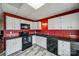 Updated kitchen features sleek black appliances and white cabinets against vibrant red walls at 84 Lake Concord Ne Rd # S, Concord, NC 28025