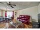 Living room featuring hardwood floors, a red leather sofa, glass coffee table, and dining area with natural light at 84 Lake Concord Ne Rd # S, Concord, NC 28025