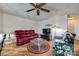 Living room with hardwood floors, decorative ceiling fan, a red leather sofa, and glass coffee table at 84 Lake Concord Ne Rd # S, Concord, NC 28025