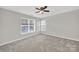 Spacious bedroom with neutral carpet, ceiling fan and natural light from large windows at 8620 Grey Squirrel Ct, Charlotte, NC 28277