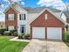 Charming two-story home with a well-maintained lawn, brick accents, and an attached two-car garage at 8620 Grey Squirrel Ct, Charlotte, NC 28277