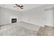 Spacious living room featuring neutral paint, carpet, ceiling fan, and a fireplace at 8620 Grey Squirrel Ct, Charlotte, NC 28277