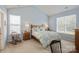 Calm bedroom featuring soft blue walls, large windows, and stylish furnishings at 8633 Sequoia Grove Ln, Charlotte, NC 28214