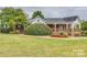 Charming clubhouse featuring a covered porch, beautiful landscaping, and a welcoming entrance for community gatherings at 8633 Sequoia Grove Ln, Charlotte, NC 28214