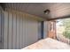 View of the home's covered front porch, with gray siding, dark trim, and metal railing, great for enjoying the outdoors at 9026 Nc 10 Hwy, Vale, NC 28168