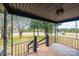 A covered front porch with a black metal railing offers a welcoming space to enjoy the outdoors at 9026 Nc 10 Hwy, Vale, NC 28168