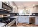 Modern kitchen with stainless appliances, granite counters, dark backsplash, and wood-look floors at 9026 Nc 10 Hwy, Vale, NC 28168