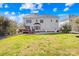 A spacious backyard with a deck, patio, lush green grass, and mature trees at 9433 Gilpatrick Ln, Huntersville, NC 28078