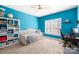 Bright blue bedroom featuring ample storage and a comfortable study space at 9433 Gilpatrick Ln, Huntersville, NC 28078