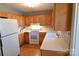 Well-lit kitchen features wood cabinets, white appliances, tile backsplash, and light countertops at 1020 Saint Paul Church Rd, Clover, SC 29710