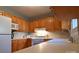 Bright kitchen boasts wood cabinetry, white appliances, and light countertops with tiled backsplash at 1020 Saint Paul Church Rd, Clover, SC 29710
