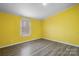 Bedroom with yellow walls, wood-look floors, a window, and wall sockets at 109 Dogwood Dr, Hickory, NC 28601