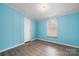 Bedroom with light blue walls, wood-look floors, and a window for natural light at 109 Dogwood Dr, Hickory, NC 28601