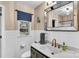 Well-lit bathroom featuring a marble countertop, white tiled walls, and gold fixtures, radiating elegance at 1101 Roundknob Ave, Salisbury, NC 28144