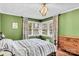 Charming bedroom featuring green walls, a corner window and hardwood floors, providing a cozy retreat at 1101 Roundknob Ave, Salisbury, NC 28144