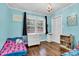 Vibrant bedroom with a blue color scheme, including dark trim, hardwood floors and a window at 1101 Roundknob Ave, Salisbury, NC 28144