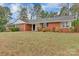 Charming red brick home featuring a well-maintained lawn and colorful landscaping at 1101 Roundknob Ave, Salisbury, NC 28144
