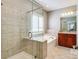 Bright bathroom offers tile surround, walk-in shower with glass door, and soaking tub at 11243 Home Place Ln, Mint Hill, NC 28227