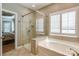Bright bathroom featuring tile surround, a walk-in shower with glass door, and a soaking tub at 11243 Home Place Ln, Mint Hill, NC 28227