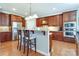 Spacious kitchen features stainless appliances, granite counters, an island with barstool seating and hardwood floors at 11243 Home Place Ln, Mint Hill, NC 28227
