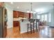 Modern kitchen with hardwood floors, cherry-wood cabinets, a breakfast bar, and stainless steel appliances at 11243 Home Place Ln, Mint Hill, NC 28227