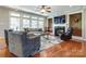 Inviting living room with hardwood floors, a fireplace, built-in shelving, and large windows at 11243 Home Place Ln, Mint Hill, NC 28227