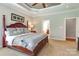 Relaxing main bedroom featuring a large bed, tray ceilings, ceiling fan, and ensuite bathroom at 11243 Home Place Ln, Mint Hill, NC 28227