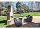 Outdoor patio area with brick fireplace and comfortable blue lounge seating at 11243 Home Place Ln, Mint Hill, NC 28227