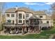 Expansive back of house with multiple decks, patio areas, and manicured lawn perfect for outdoor living and entertaining at 130 Brick Kiln Way, Mooresville, NC 28117