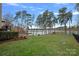 Expansive backyard featuring lush lawn, mature trees, and serene lake views at 130 Brick Kiln Way, Mooresville, NC 28117