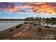 Lakeside backyard at sunset with a pathway leading to a private dock perfect for enjoying waterfront living at 130 Brick Kiln Way, Mooresville, NC 28117
