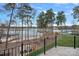 Balcony overlooking backyard with a fire pit, mature trees, and serene lake views at 130 Brick Kiln Way, Mooresville, NC 28117