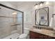 Bathroom featuring tiled glass shower, granite countertop, and stylish vanity with decorative mirror at 130 Brick Kiln Way, Mooresville, NC 28117