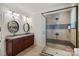 Modern bathroom with a glass-enclosed shower, dual sinks, granite countertops, and decorative mirrors at 130 Brick Kiln Way, Mooresville, NC 28117