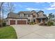 Stately home with a three-car garage, stone accents, and lush landscaping at 130 Brick Kiln Way, Mooresville, NC 28117