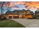 Stately home showcasing a large driveway and a well-manicured lawn during a beautiful sunset at 130 Brick Kiln Way, Mooresville, NC 28117