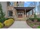 Stunning stone home featuring a covered front entry with elegant wooden double doors and meticulously landscaped surroundings at 130 Brick Kiln Way, Mooresville, NC 28117