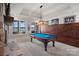 Game room with a pool table, stone fireplace, wood accent wall, and stunning lake views at 130 Brick Kiln Way, Mooresville, NC 28117