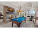 Entertaining game room with stone fireplace, pool table, and views of the serene backyard at 130 Brick Kiln Way, Mooresville, NC 28117