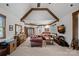 Spacious living room featuring exposed wood beams, ample seating, and a built-in display cabinet at 130 Brick Kiln Way, Mooresville, NC 28117