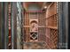 Elaborate wine cellar featuring wooden racks, slate flooring, and wrought iron door at 130 Brick Kiln Way, Mooresville, NC 28117