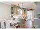 A muted green kitchen and dining area with wooden floors, pendant lighting and stainless steel appliances at 130 N Smallwood Pl, Charlotte, NC 28216