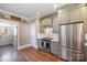 This kitchen has stainless steel appliances, wooden floors, and muted green cabinets at 130 N Smallwood Pl, Charlotte, NC 28216