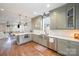 A kitchen with stainless steel appliances, muted green cabinets, and an adjacent dining area at 130 N Smallwood Pl, Charlotte, NC 28216