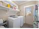 Efficient laundry room with modern washer and dryer, convenient shelving, and an exterior door at 130 N Smallwood Pl, Charlotte, NC 28216