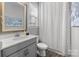 Well-lit bathroom features a modern vanity with a framed mirror and a shower with a patterned curtain at 13725 Laughing Gull Dr, Charlotte, NC 28278