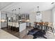Open kitchen featuring gray cabinets, stainless appliances, island seating, and adjacent dining area at 13725 Laughing Gull Dr, Charlotte, NC 28278