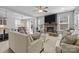 Cozy living room with stone fireplace, modern ceiling fan, and seamless access to the dining area at 13725 Laughing Gull Dr, Charlotte, NC 28278