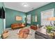Comfortable living room featuring green walls, a modern sofa, and natural light from a bright window at 13725 Laughing Gull Dr, Charlotte, NC 28278